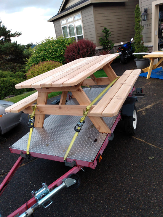 A traditional wood picnic table loaded up on a trailer for shipping